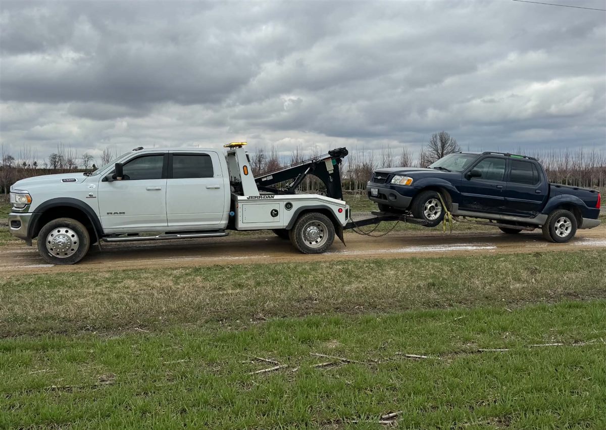 we buy junk cars Milwaukee, hauling a blue Ford Explorer Sport Trac