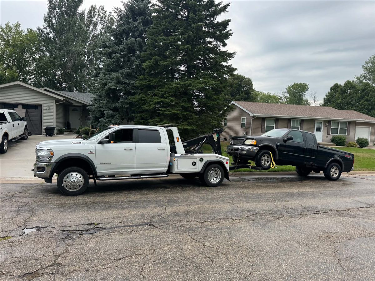 we buy junk cars Milwaukee, black Ford F150 junk truck on our wheel lift