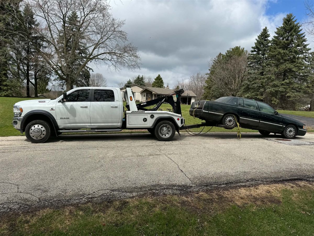 we buy junk cars Milwaukee, towing a 1990s Cadillac that no longer starts